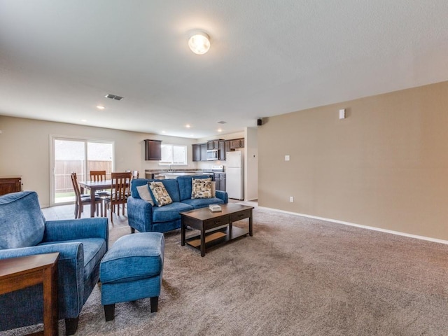 living room with light carpet, visible vents, baseboards, and recessed lighting