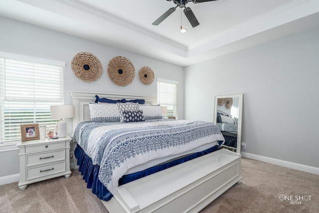 bedroom with baseboards, a tray ceiling, crown molding, and light colored carpet