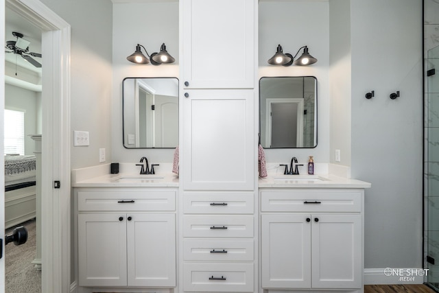 bathroom with a ceiling fan, a stall shower, a sink, and double vanity