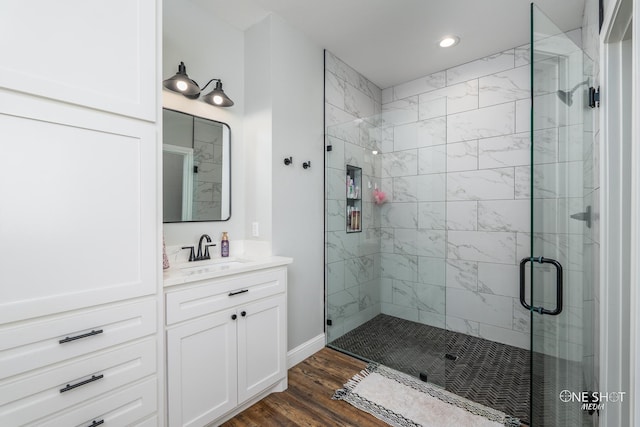 full bath featuring a stall shower, wood finished floors, vanity, and recessed lighting