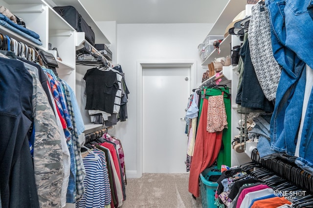 walk in closet featuring light colored carpet