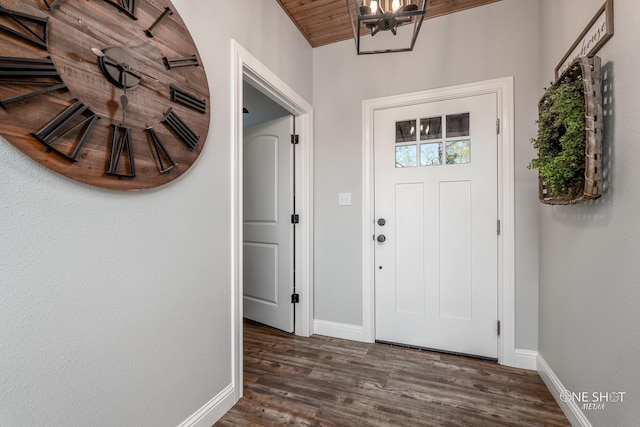 foyer with baseboards, a chandelier, and dark wood-style flooring