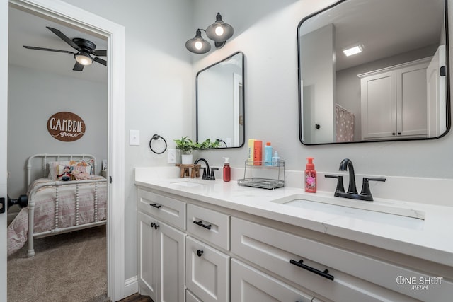 ensuite bathroom featuring double vanity, a sink, a ceiling fan, and connected bathroom