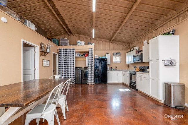 kitchen featuring white cabinets, washer and clothes dryer, finished concrete floors, black appliances, and a sink