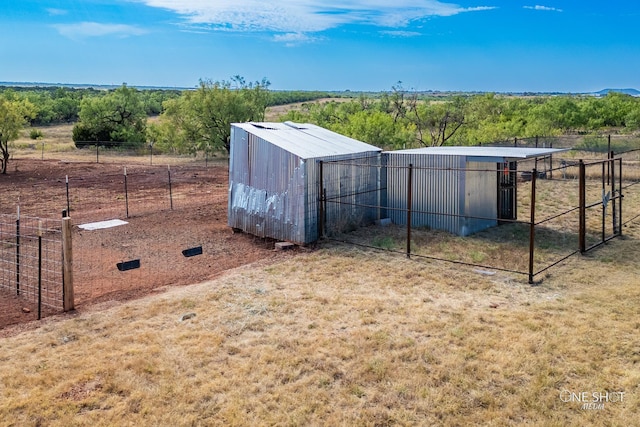 view of pole building featuring fence and a rural view