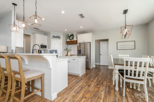 3085 County Road 131, Tuscola, TX 79562 - kitchen featuring stainless steel appliances, tasteful backsplash, a kitchen bar, dark wood-type flooring, and light countertops