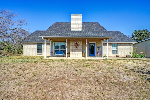 rear view of property with a lawn