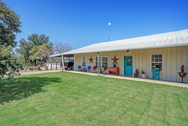 back of property featuring a patio area and a lawn