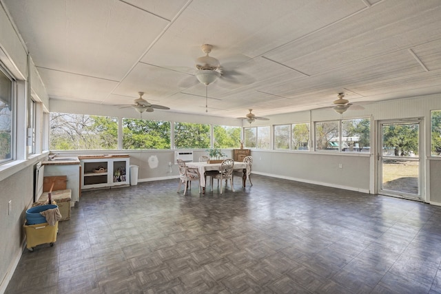 unfurnished sunroom with plenty of natural light and ceiling fan