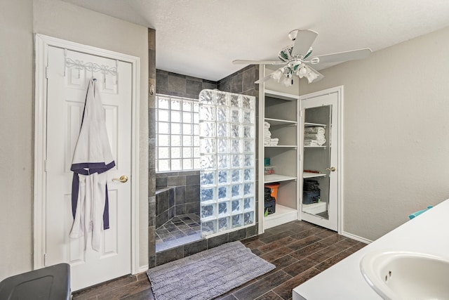 bathroom with hardwood / wood-style floors, tiled shower, a textured ceiling, vanity, and ceiling fan