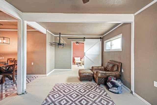 sitting room with concrete flooring, crown molding, and a barn door