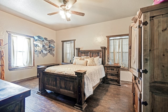 bedroom with ceiling fan, dark wood-type flooring, and a textured ceiling