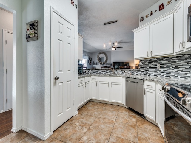 kitchen featuring stainless steel appliances, decorative backsplash, light wood-type flooring, a textured ceiling, and kitchen peninsula