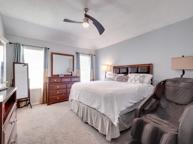 bedroom with multiple windows, light carpet, a textured ceiling, and ceiling fan