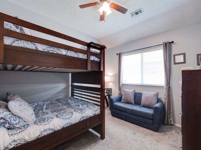 carpeted bedroom with ceiling fan, a textured ceiling, and lofted ceiling