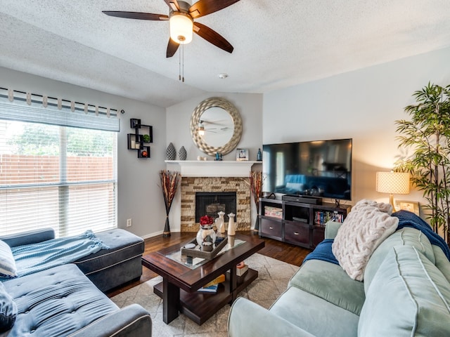 living room featuring hardwood / wood-style floors, ceiling fan, a textured ceiling, and a fireplace