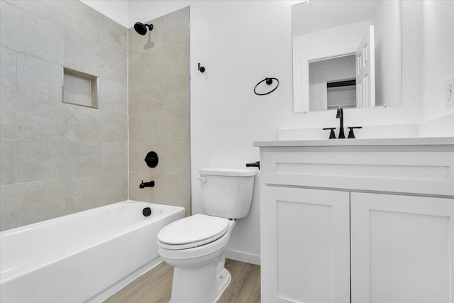 full bathroom featuring tiled shower / bath combo, wood-type flooring, toilet, and vanity