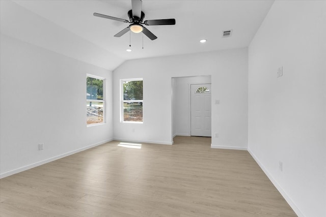 empty room featuring ceiling fan, vaulted ceiling, and light wood-type flooring