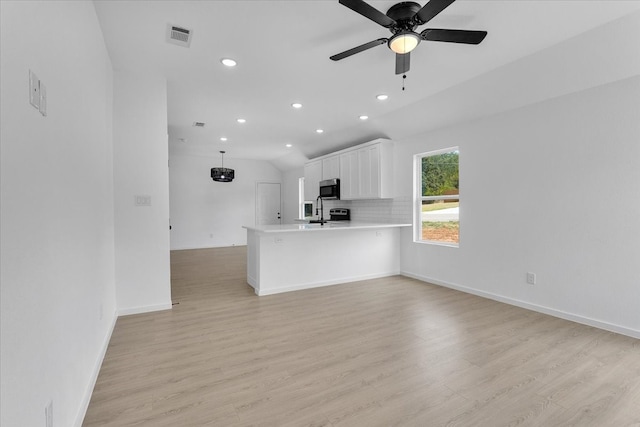 unfurnished living room with ceiling fan, light hardwood / wood-style floors, and vaulted ceiling