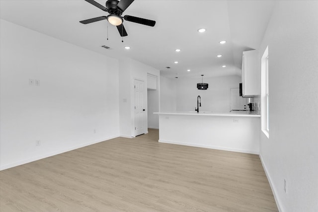 unfurnished living room featuring ceiling fan, light hardwood / wood-style flooring, and sink