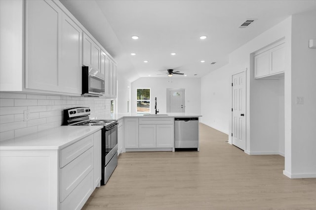 kitchen with appliances with stainless steel finishes, light hardwood / wood-style floors, white cabinetry, and sink