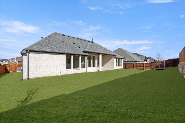 2001 Rockwood Ln, Mansfield, TX 76063 - back of property featuring a fenced backyard, a yard, and a shingled roof