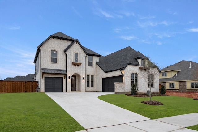 french country inspired facade featuring driveway, a shingled roof, a front yard, and fence