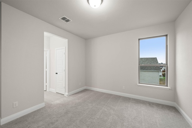 empty room featuring baseboards, a ceiling fan, visible vents, and light colored carpet