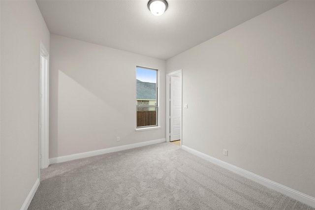 spare room with lofted ceiling, baseboards, visible vents, and carpet