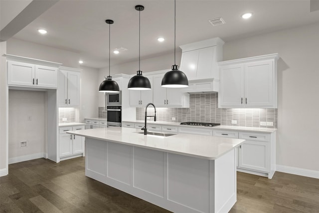 kitchen with dark wood finished floors, white cabinetry, stainless steel appliances, and light countertops