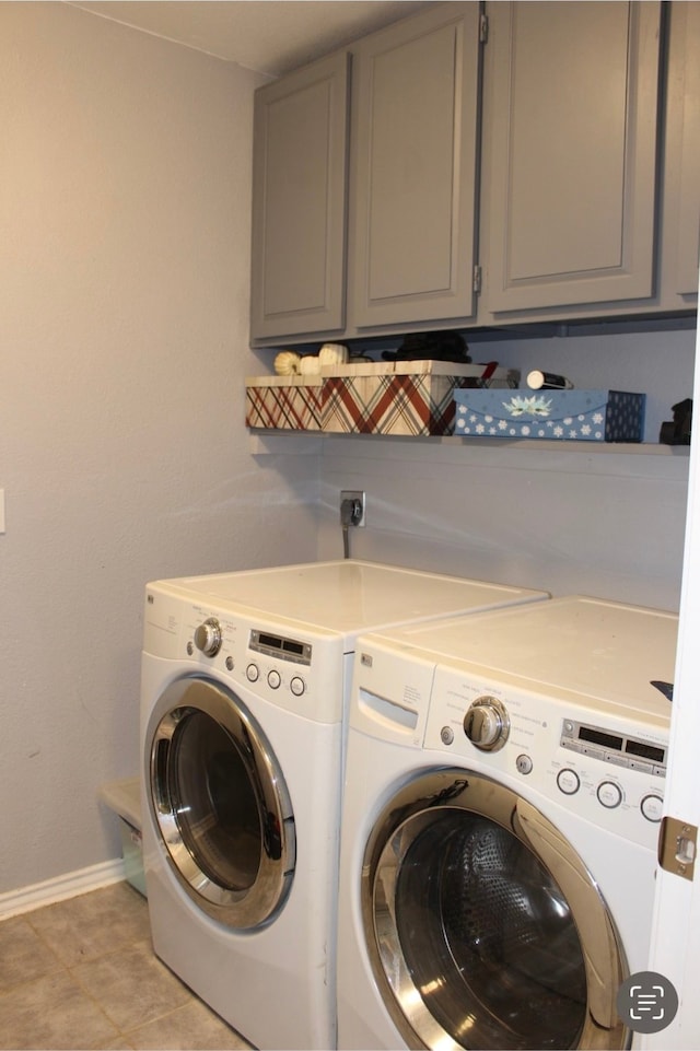 laundry area featuring cabinets, light tile patterned floors, and separate washer and dryer