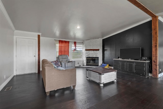 living room featuring crown molding, dark hardwood / wood-style flooring, and a fireplace