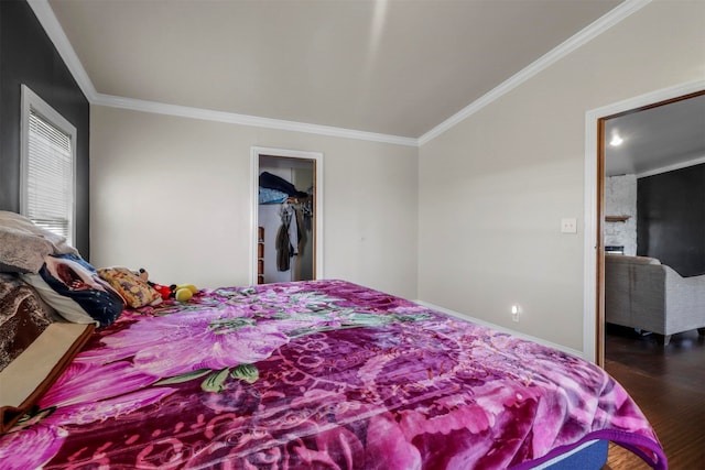 bedroom with ornamental molding, a spacious closet, a closet, and wood-type flooring