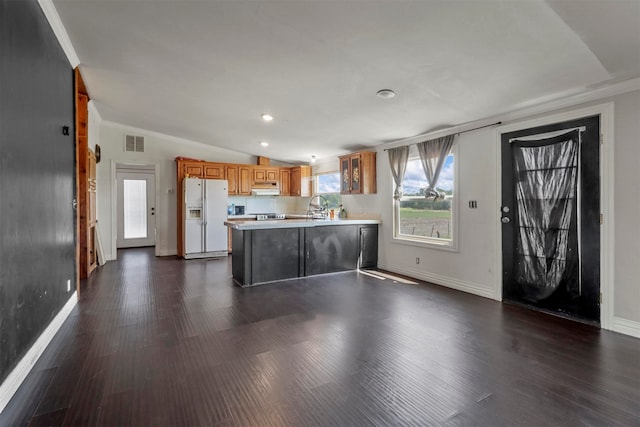 kitchen featuring dark hardwood / wood-style floors, sink, lofted ceiling, white fridge with ice dispenser, and range hood