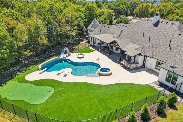 view of swimming pool with a water slide, a diving board, and a patio