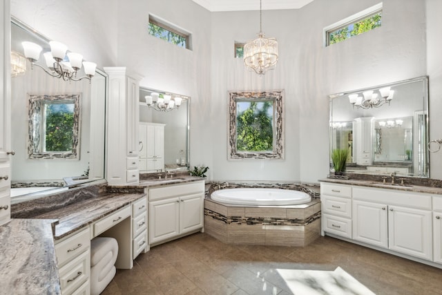 bathroom featuring a towering ceiling, tiled bath, vanity, crown molding, and tile patterned flooring