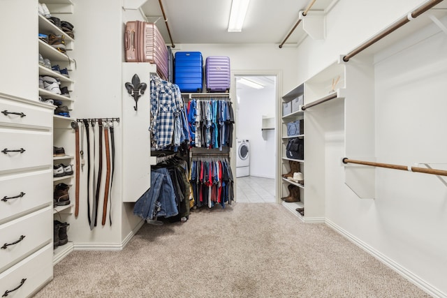 spacious closet featuring washer / dryer and light colored carpet