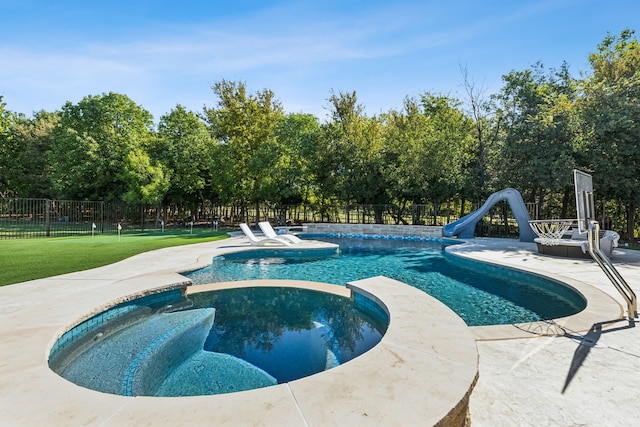 view of swimming pool featuring a water slide, an in ground hot tub, and a patio area