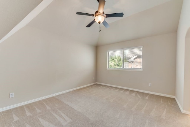 unfurnished room featuring light colored carpet, vaulted ceiling, and ceiling fan