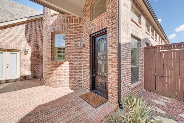 view of exterior entry with a patio