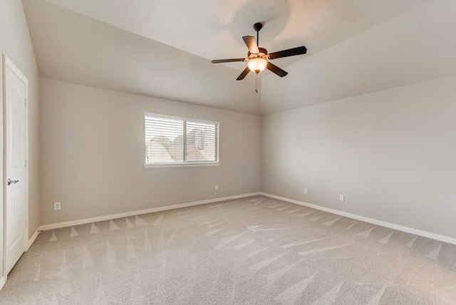 empty room featuring light colored carpet, vaulted ceiling, and ceiling fan