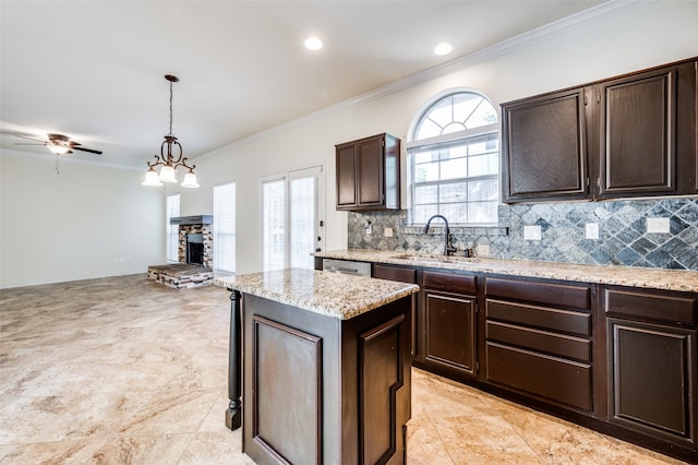 kitchen with light tile patterned floors, decorative light fixtures, sink, ceiling fan, and tasteful backsplash