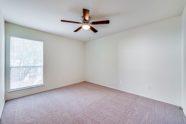 carpeted spare room featuring ceiling fan