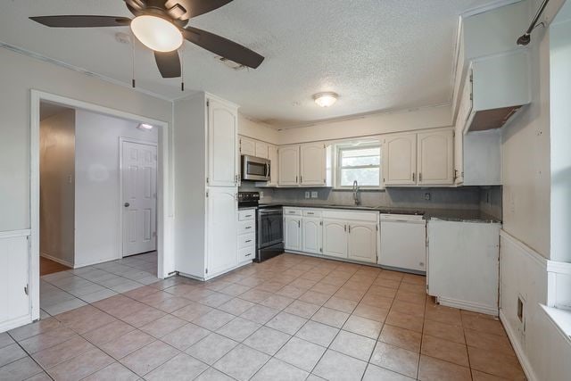 kitchen with white dishwasher, range with electric stovetop, a sink, stainless steel microwave, and dark countertops