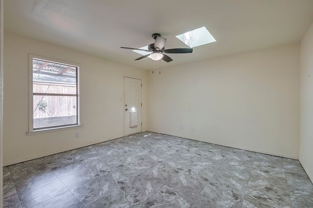 unfurnished room with a skylight and a ceiling fan