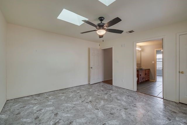 unfurnished room featuring a ceiling fan, a skylight, and visible vents