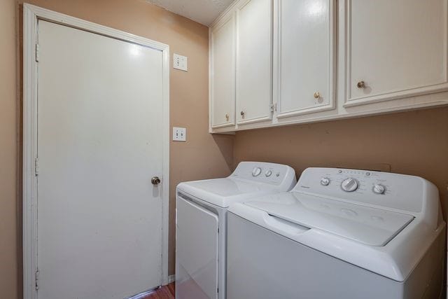 laundry room featuring washing machine and dryer and cabinet space