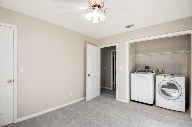 clothes washing area with light carpet, washer and clothes dryer, and ceiling fan