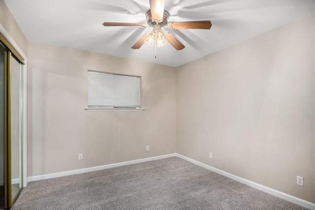 carpeted spare room featuring ceiling fan