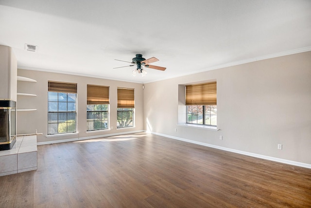 unfurnished living room with a healthy amount of sunlight, ceiling fan, crown molding, and hardwood / wood-style floors